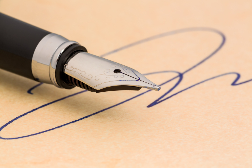 A fountain pen resting on a recently signed Will.