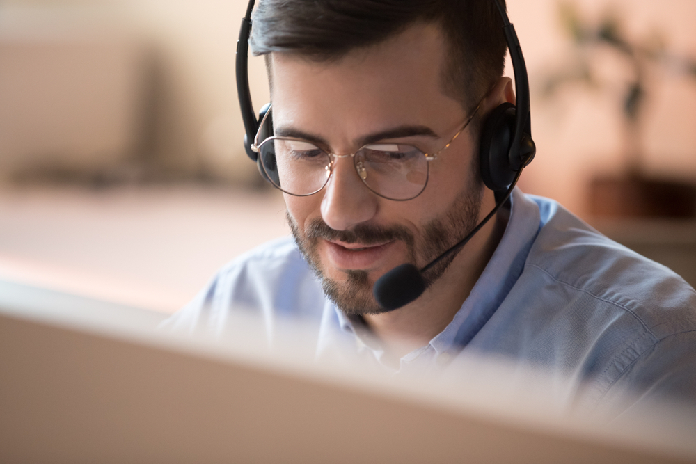 A person speaking to someone through a headset.
