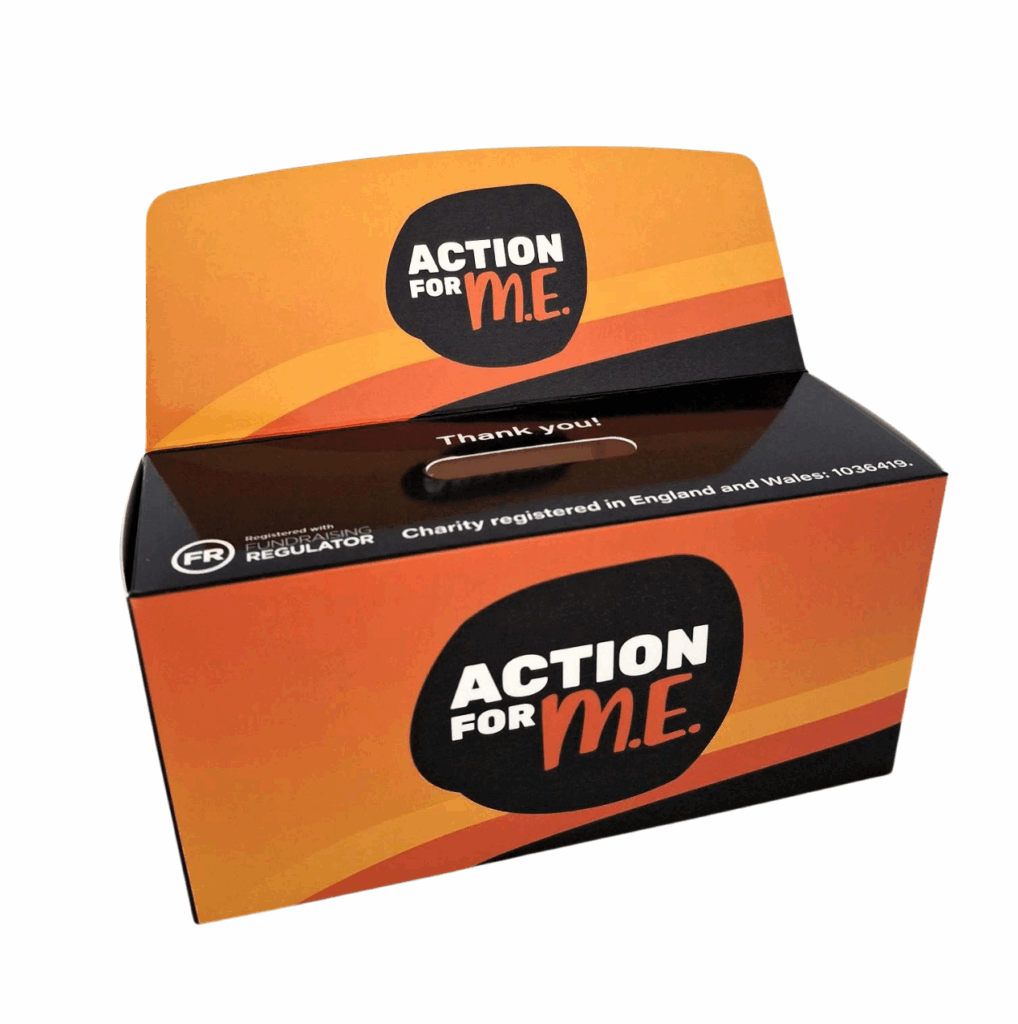 A donation box with the logo 'ACTION FOR M.E.' in white and orange letters on a black background. The box features an orange and black gradient design. Its top flap is open, showing a slot for donations with the text 'Thank you!' above it. The front of the box includes the text 'Charity registered in England and Wales, 1036419' and a small logo indicating regulation by the Fundraising Regulator.