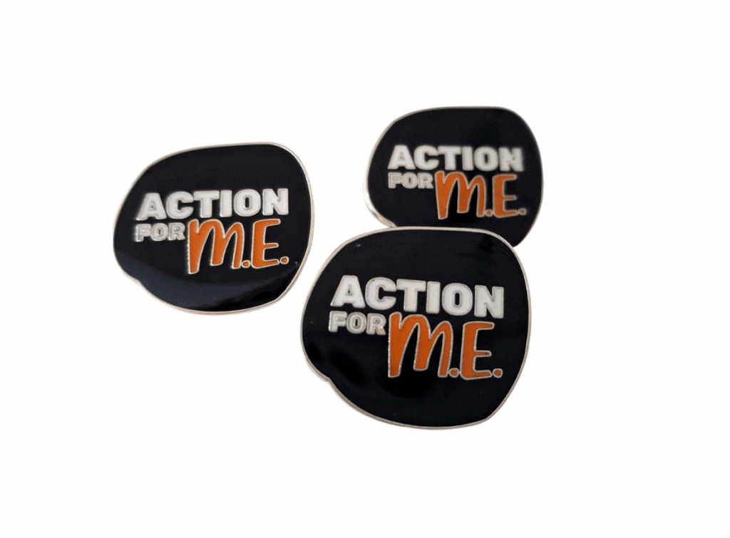 Three dark blue pins displaying the text 'ACTION FOR M.E.' with 'ACTION' in white, 'FOR' in gray, and 'M.E.' in orange.